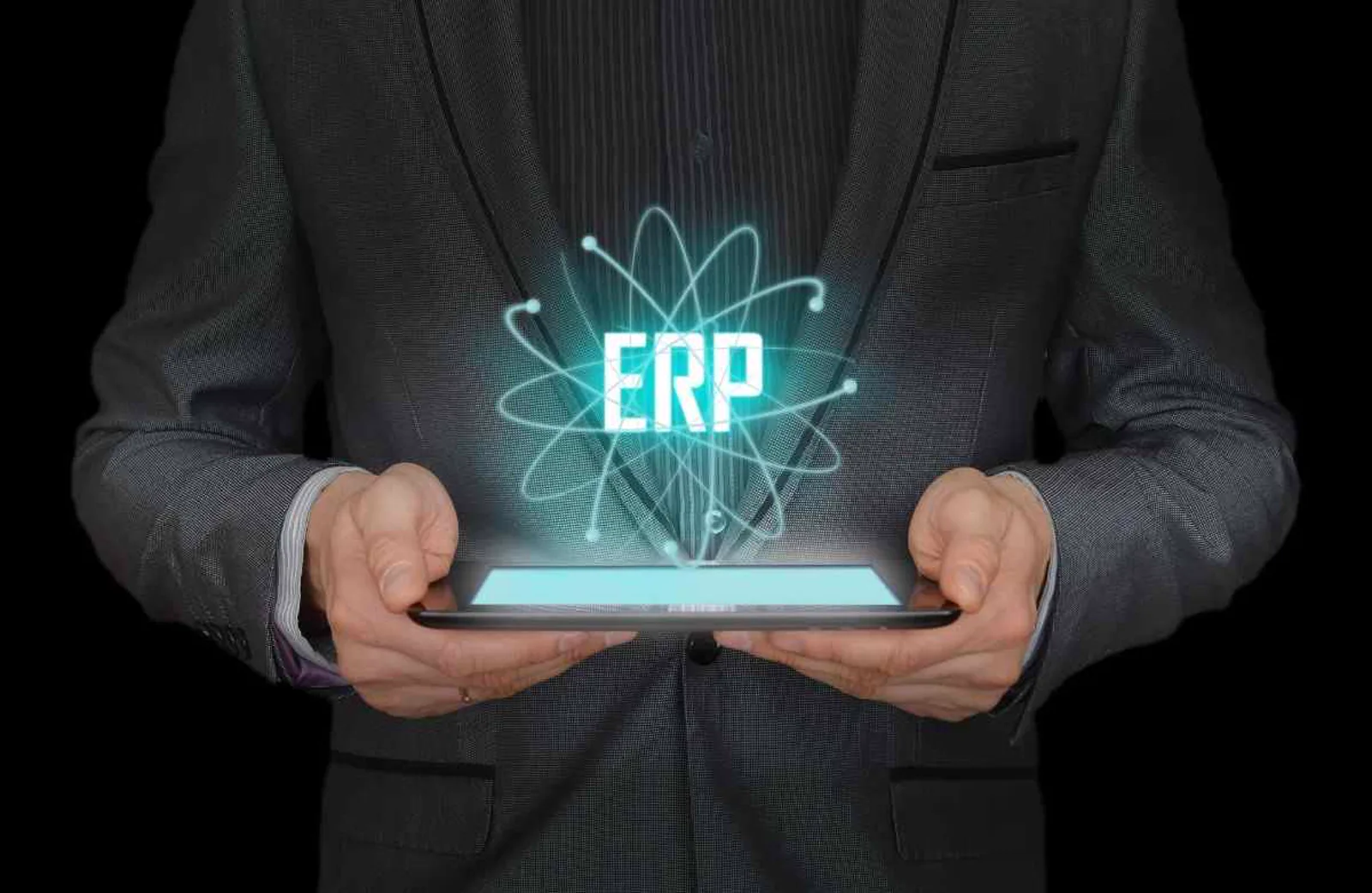 Businessman holding a tablet with a glowing ERP hologram, representing digital ERP modernization