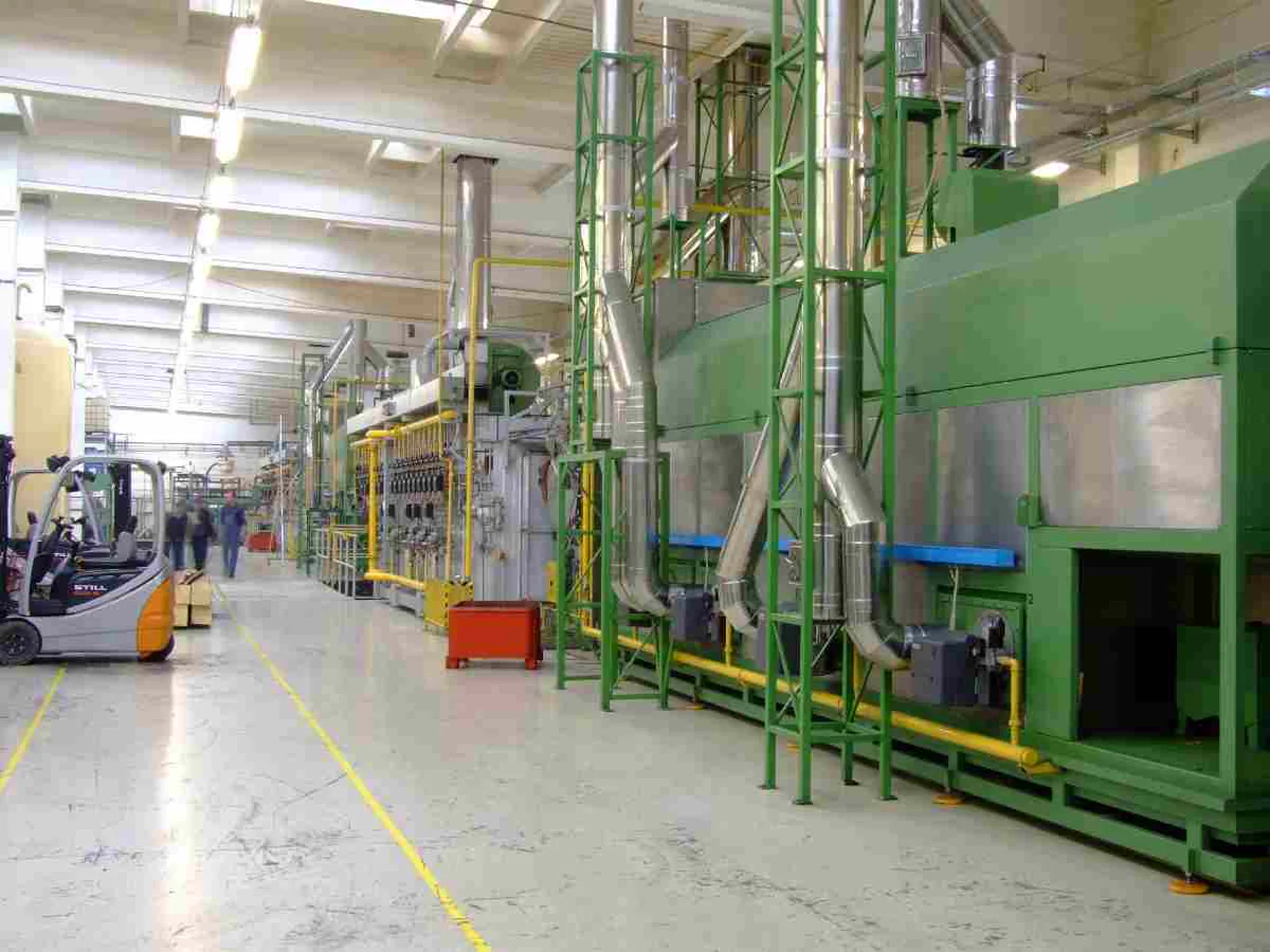 Automotive manufacturing plant production line with industrial machinery and a forklift
