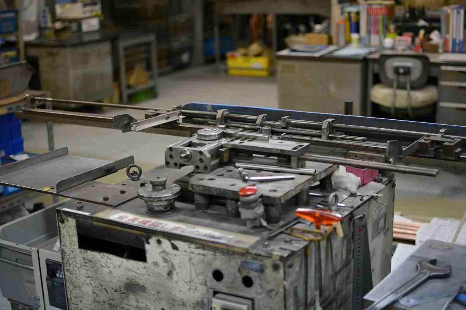 Cluttered legacy workshop with aging manufacturing equipment and tools