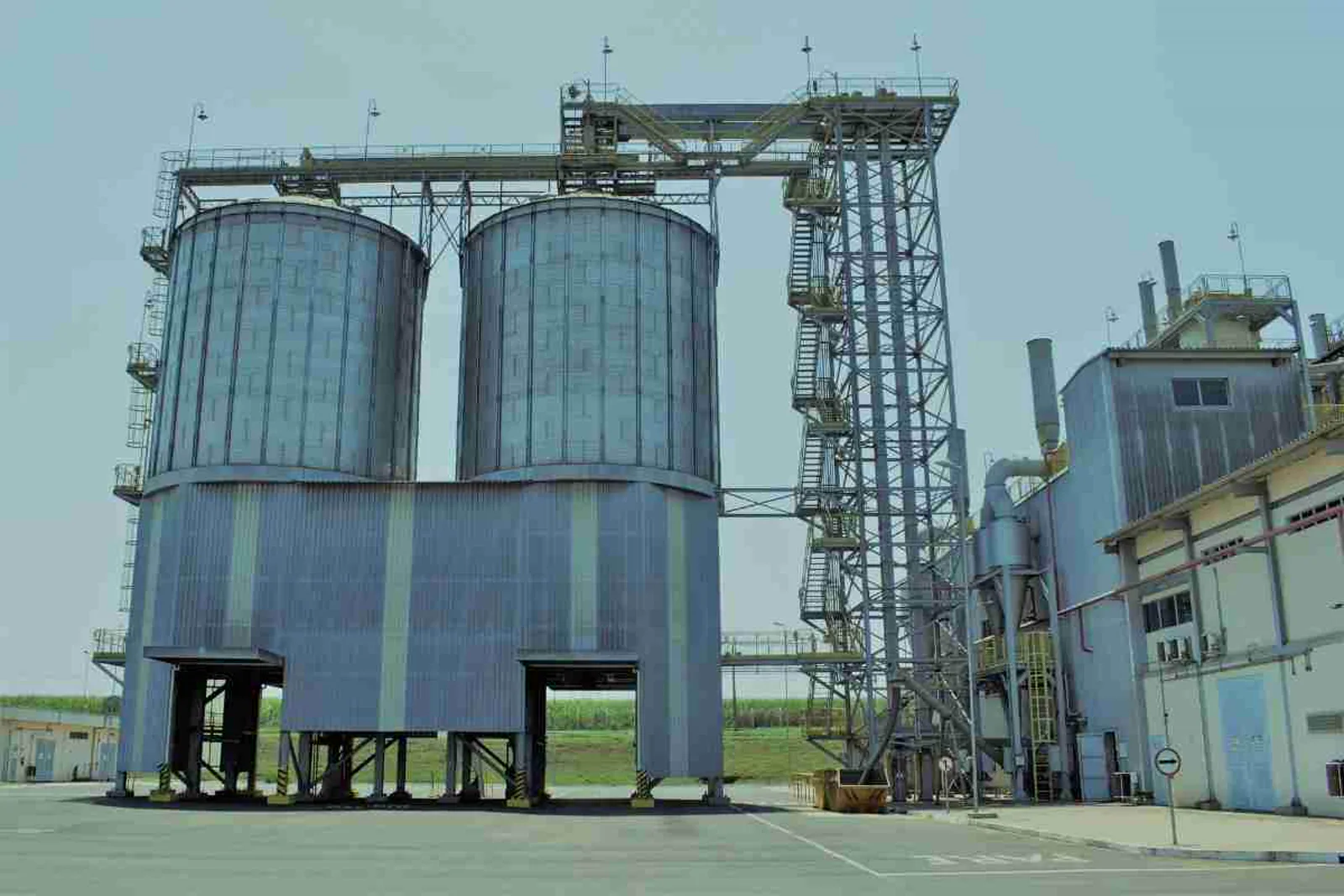 Exterior view of a manufacturing facility with large grain storage silos