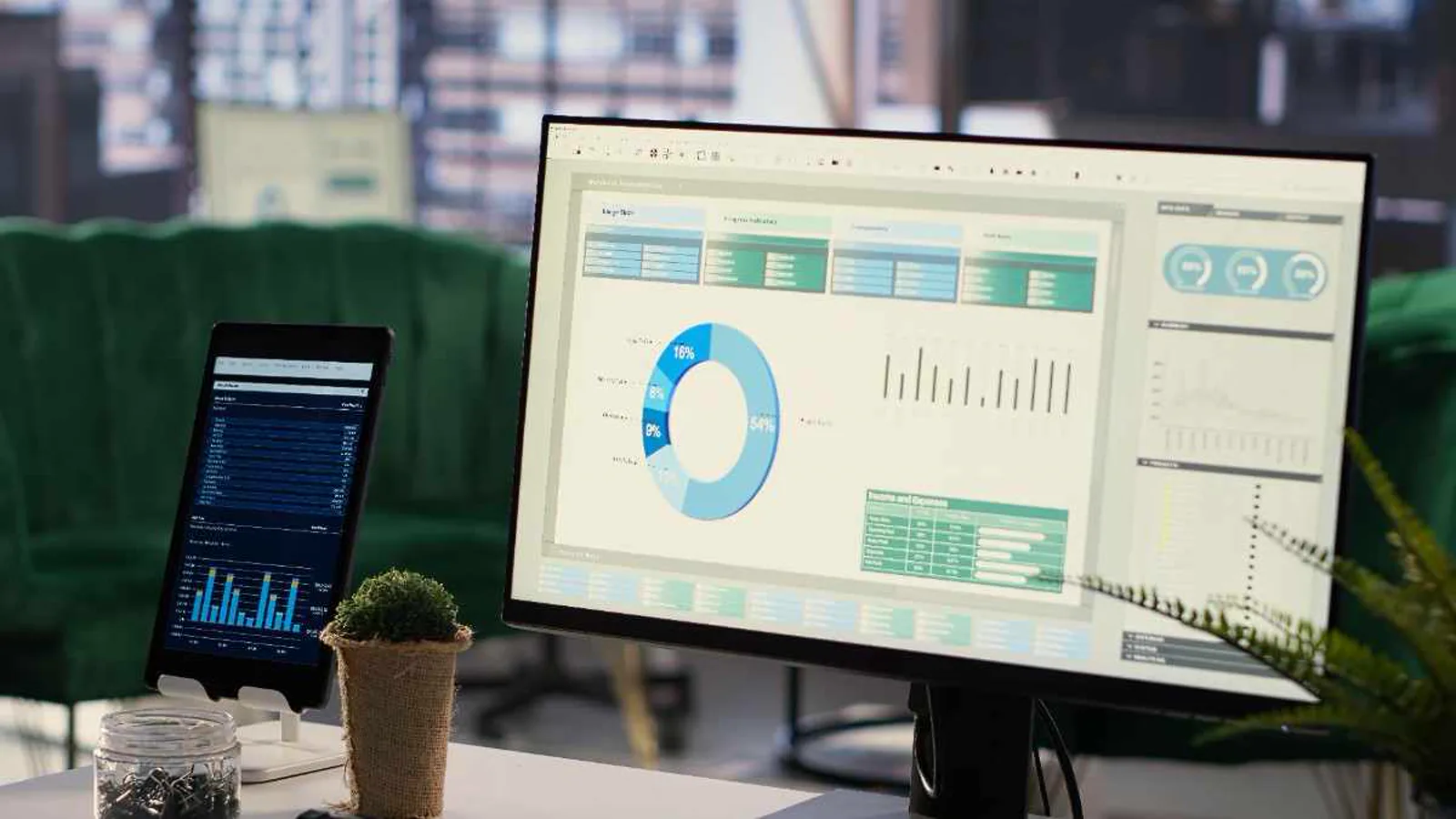 Manufacturing ERP dashboard showing production and performance charts on a monitor and tablet