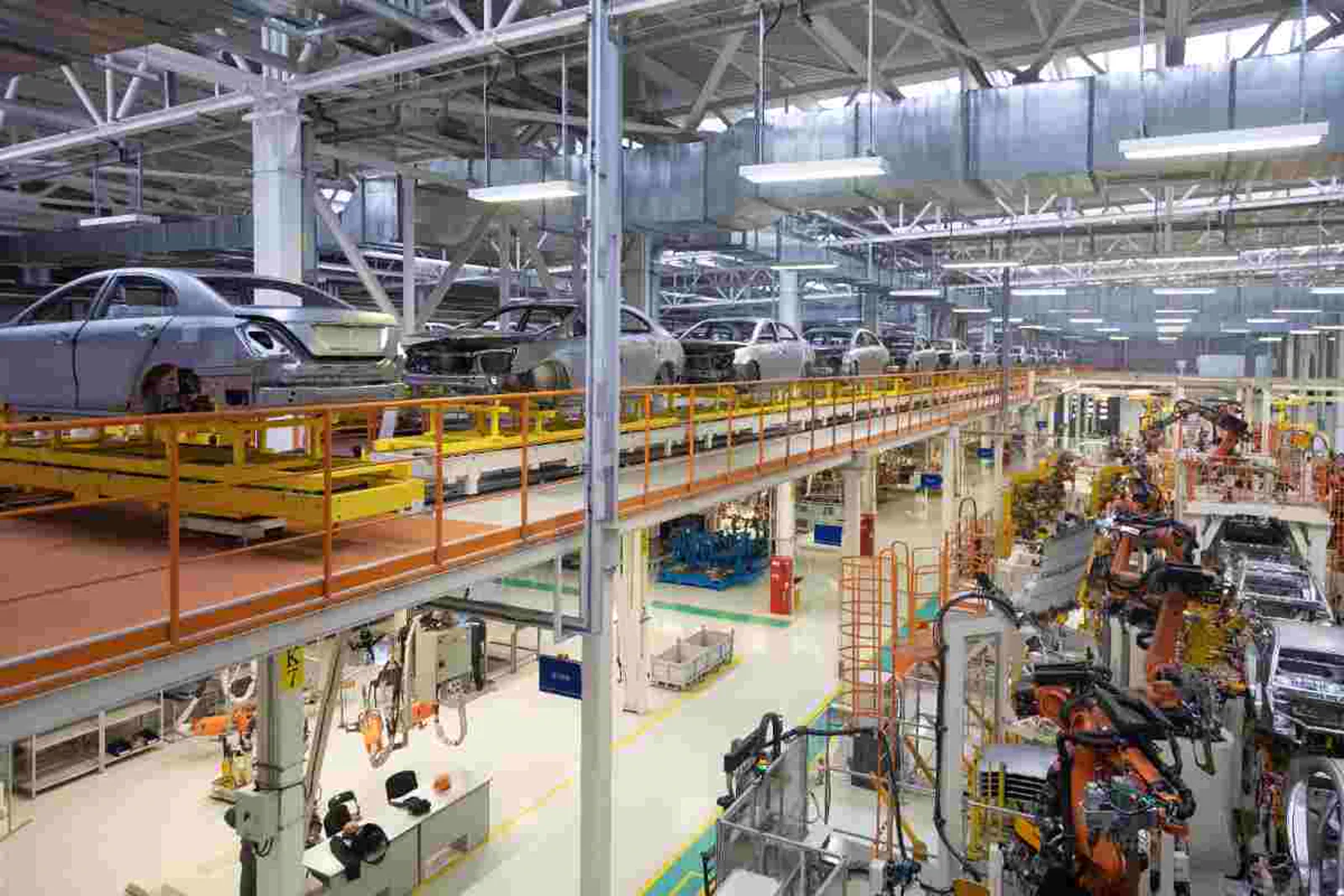 Modern automotive manufacturing plant with vehicles on an elevated assembly line
